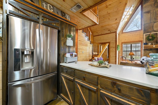 kitchen with stainless steel refrigerator with ice dispenser, wooden walls, lofted ceiling, and wood ceiling