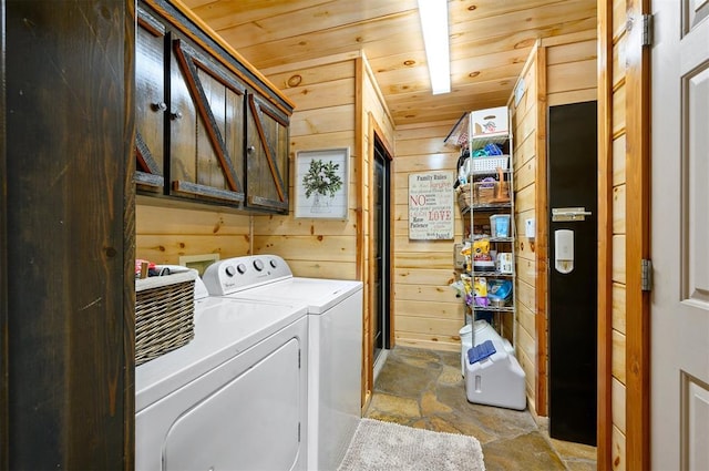 clothes washing area featuring washing machine and clothes dryer, wood walls, cabinets, and wooden ceiling