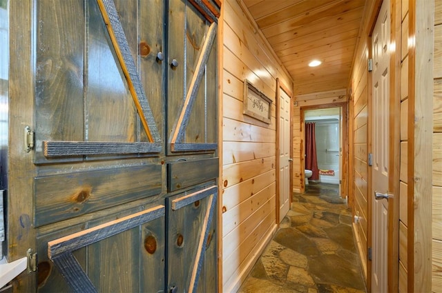 corridor featuring wooden walls and wood ceiling