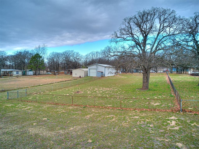 view of yard with an outbuilding, a rural view, and a garage