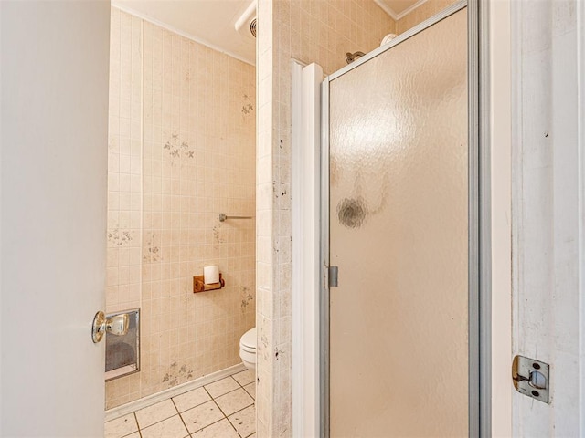 bathroom featuring tile patterned flooring, toilet, walk in shower, and tile walls