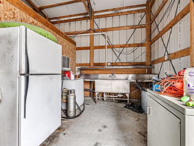 garage with white refrigerator and washer / dryer