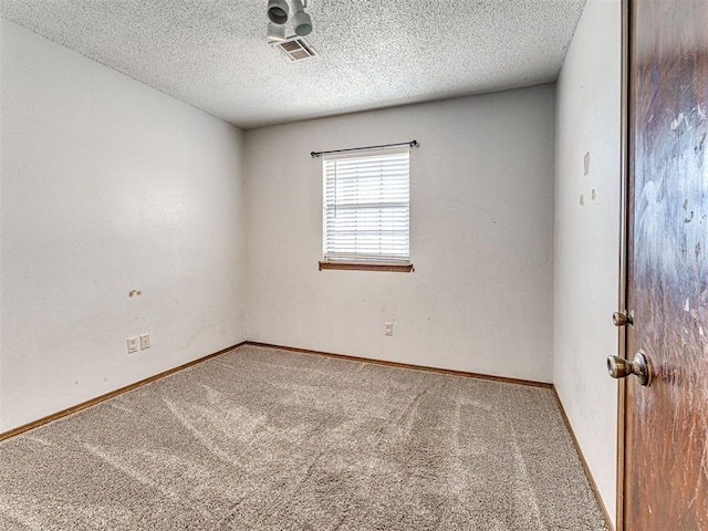 carpeted empty room with a textured ceiling