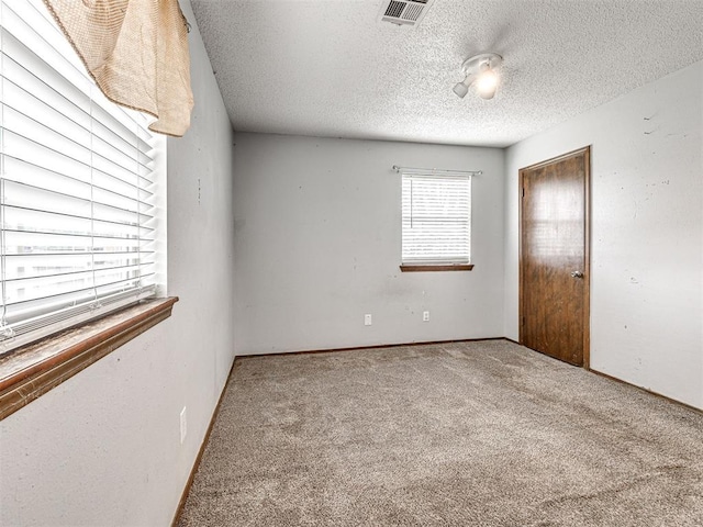 unfurnished bedroom with carpet flooring, a textured ceiling, and a closet