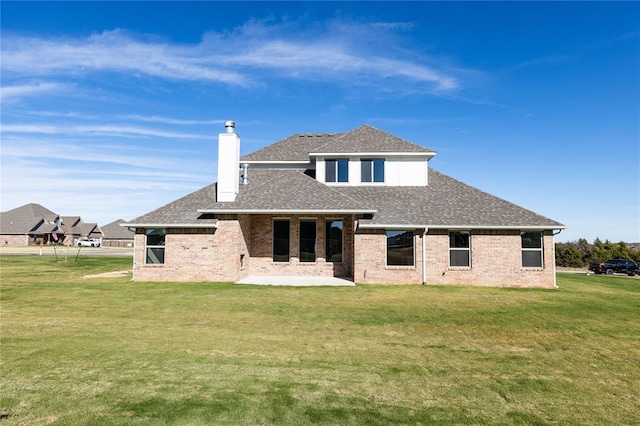 back of property with a patio area and a yard