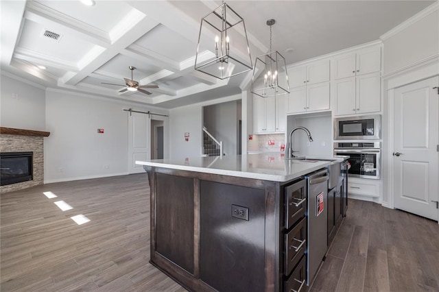 kitchen featuring white cabinets, pendant lighting, a kitchen island with sink, and stainless steel appliances