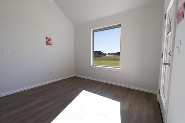 spare room with lofted ceiling and dark hardwood / wood-style floors