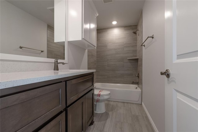 full bathroom with vanity, tiled shower / bath combo, and toilet