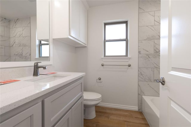 full bathroom featuring wood-type flooring, vanity, toilet, and tiled shower / bath combo