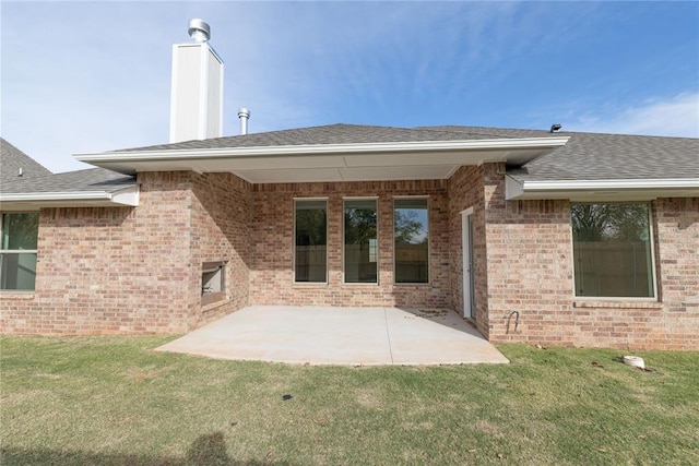 back of house with a lawn and a patio