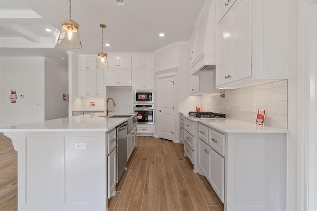 kitchen with white cabinets, decorative light fixtures, light wood-type flooring, and stainless steel appliances