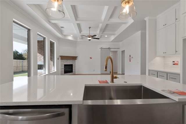 kitchen with coffered ceiling, ceiling fan, a barn door, dishwasher, and hanging light fixtures