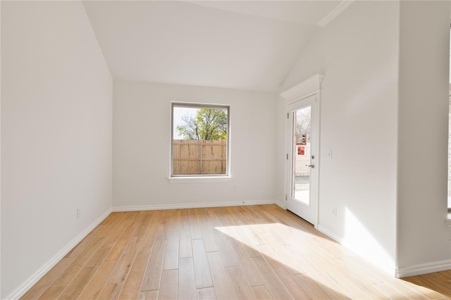 unfurnished room featuring lofted ceiling and light wood-type flooring