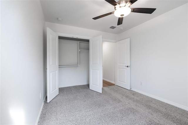 unfurnished bedroom with ceiling fan, a closet, and light carpet