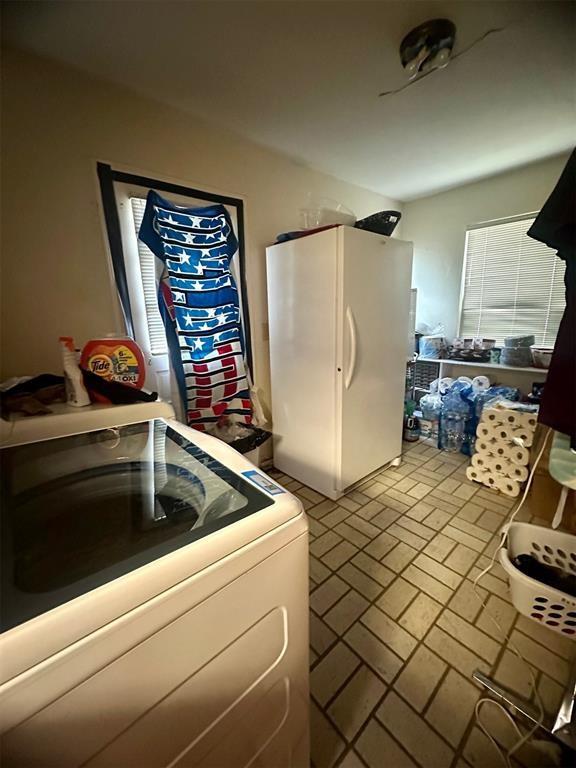 kitchen featuring washer / clothes dryer and white fridge