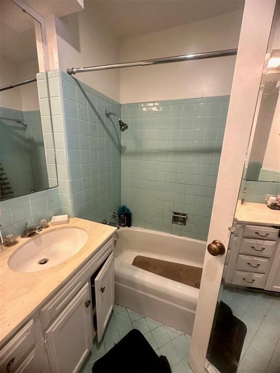 bathroom with tile patterned flooring, vanity, tiled shower / bath, and backsplash