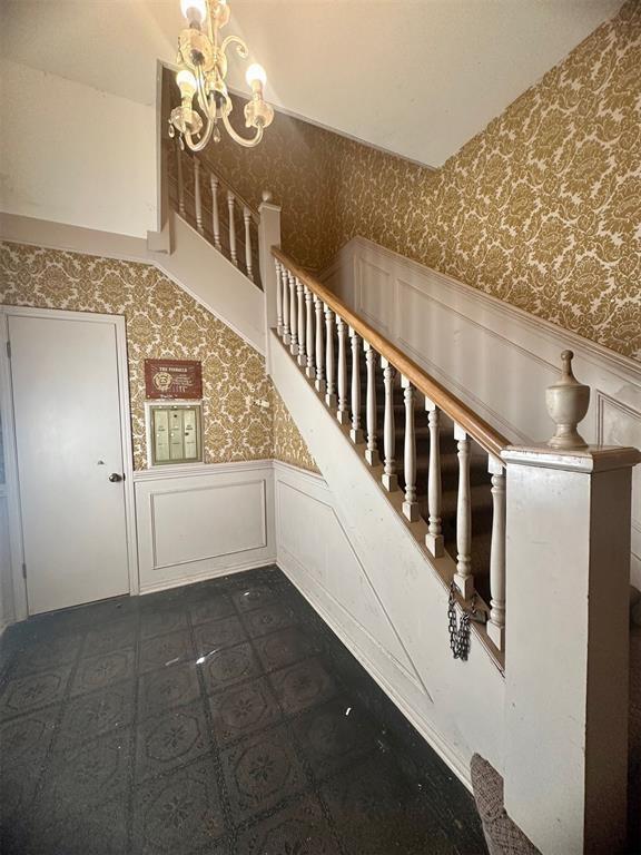 staircase featuring a chandelier