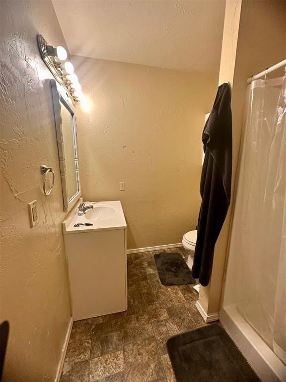 bathroom featuring vanity, curtained shower, and toilet