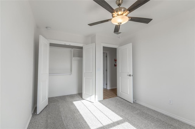 unfurnished bedroom with ceiling fan, light colored carpet, and a closet