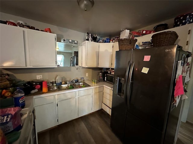 kitchen with sink, white cabinetry, dark wood-type flooring, and fridge with ice dispenser