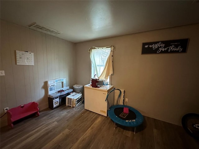 miscellaneous room with dark hardwood / wood-style flooring, a wall unit AC, and wood walls