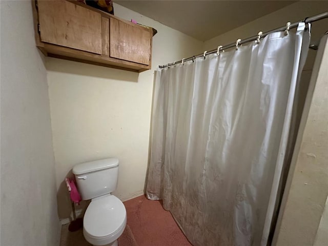 bathroom with a shower with shower curtain and toilet