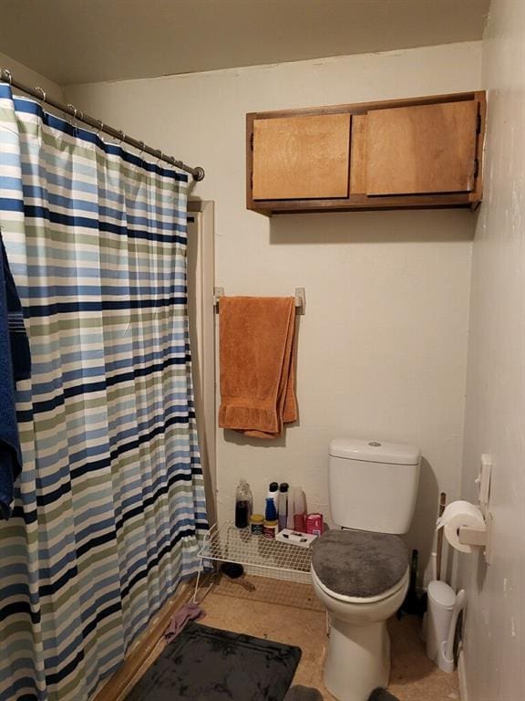 bathroom with curtained shower and toilet