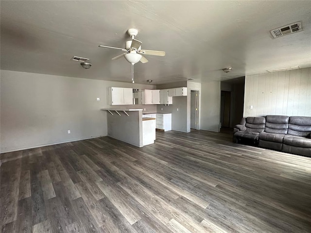 unfurnished living room with ceiling fan, dark wood-type flooring, and visible vents