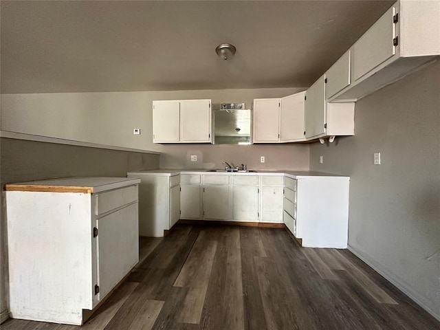 kitchen with dark wood-style floors, white cabinetry, light countertops, and a sink