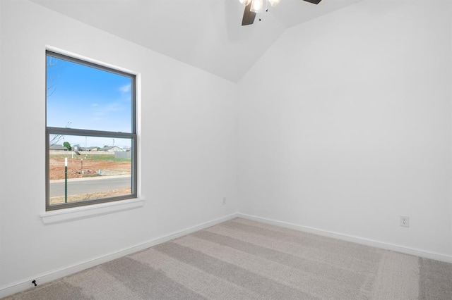 empty room with carpet, vaulted ceiling, plenty of natural light, and ceiling fan