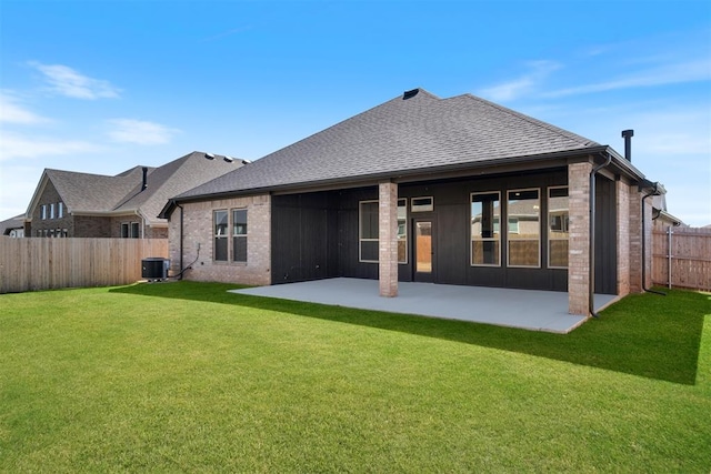 rear view of house with a patio area, central air condition unit, and a yard