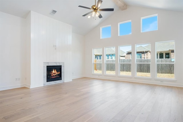 unfurnished living room featuring high vaulted ceiling, ceiling fan, light wood-type flooring, a fireplace, and beamed ceiling