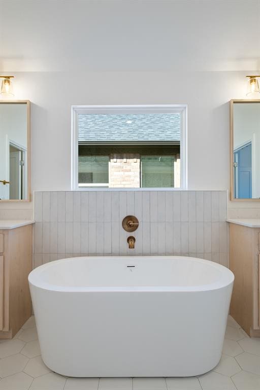 bathroom with tile patterned flooring, vanity, and a tub