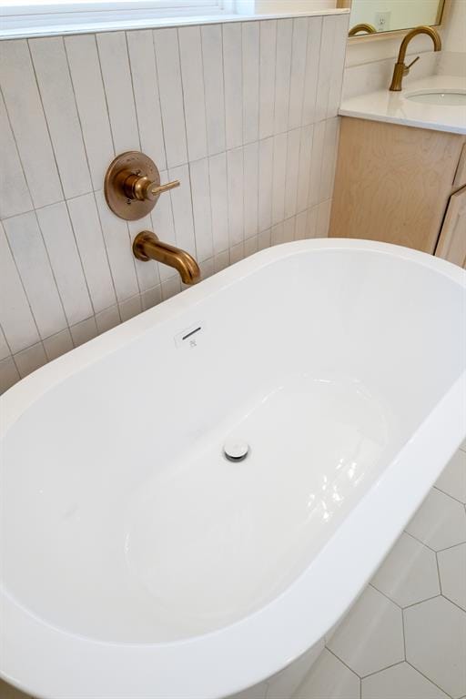 bathroom with sink, a bath, and tile patterned flooring