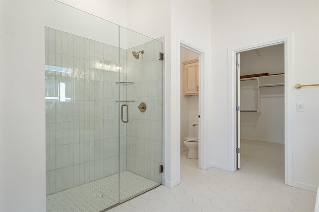 bathroom featuring tile patterned floors, toilet, and a shower with door