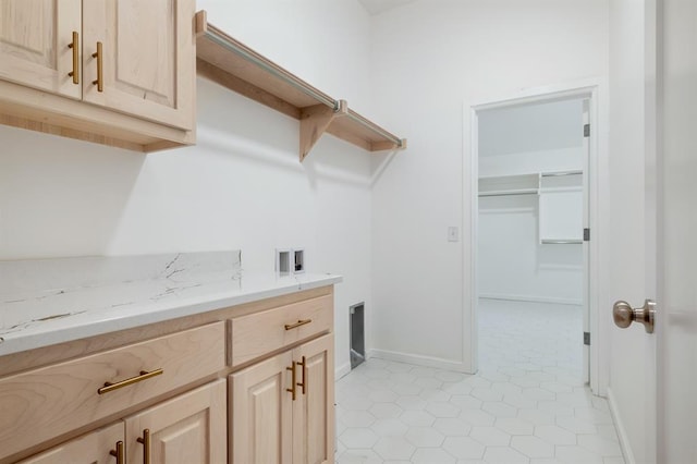 laundry room featuring light tile patterned floors, cabinets, and washer hookup