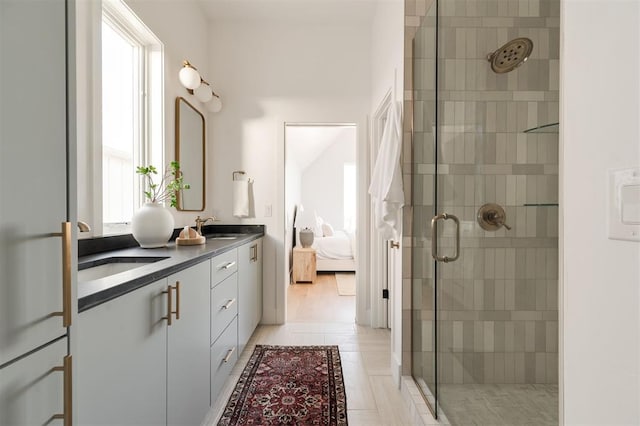 bathroom with tile patterned floors, vanity, a healthy amount of sunlight, and a shower with shower door