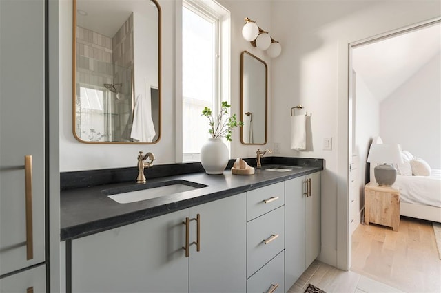 bathroom with hardwood / wood-style floors, vanity, and a shower