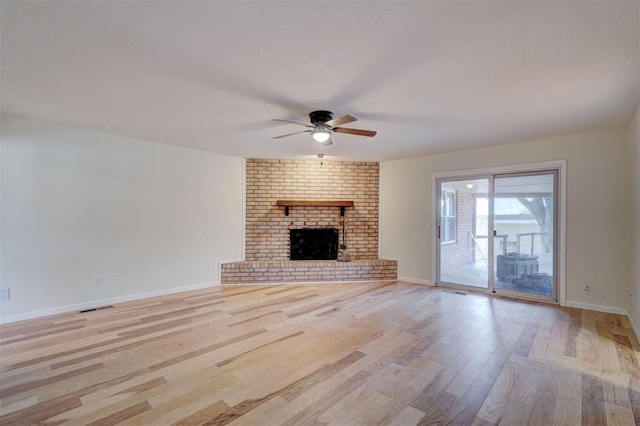 unfurnished living room with ceiling fan, light hardwood / wood-style floors, and a brick fireplace