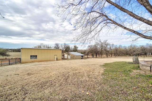 view of yard featuring a rural view and an outdoor structure