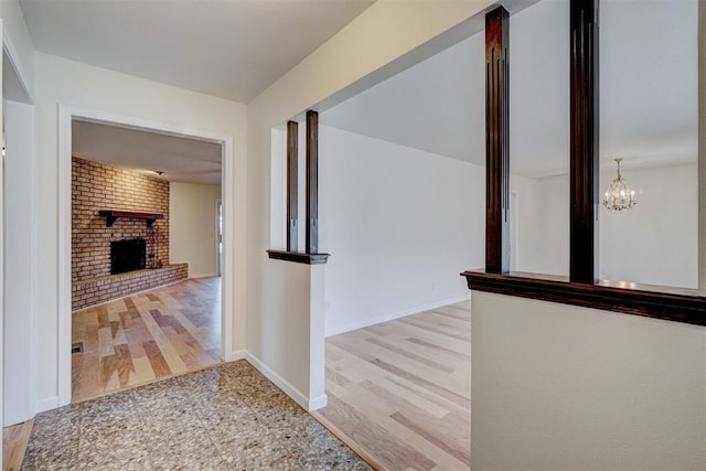 hall with light hardwood / wood-style flooring and an inviting chandelier