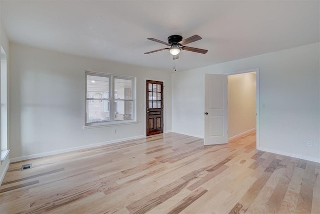 empty room with ceiling fan and light hardwood / wood-style flooring