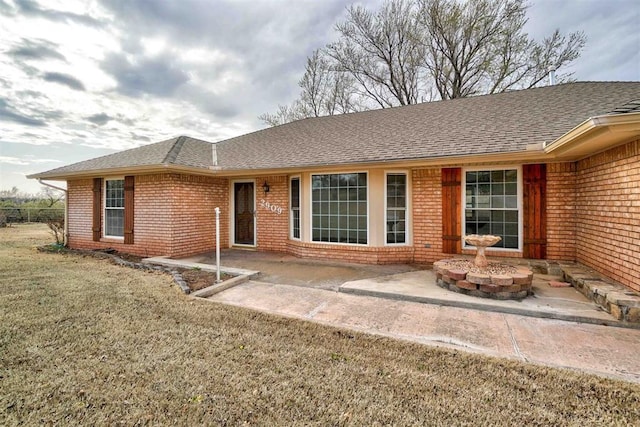 ranch-style house with a front yard and a patio