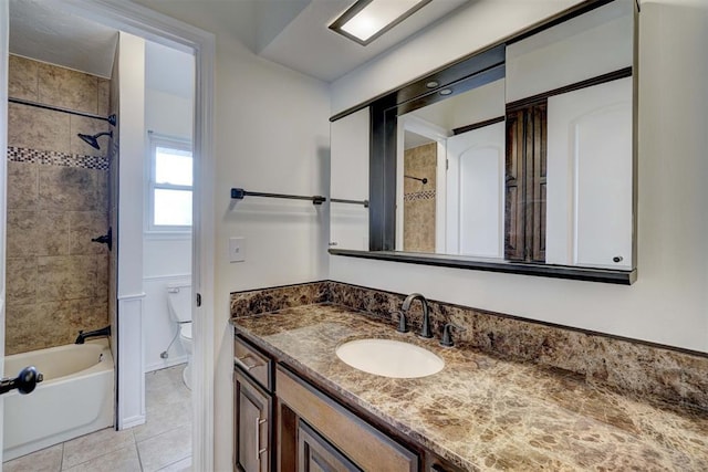 full bathroom featuring tile patterned floors, vanity, tiled shower / bath combo, and toilet