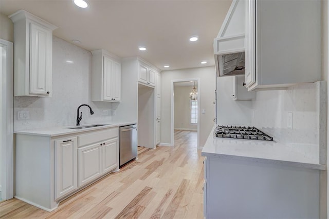 kitchen featuring light wood-type flooring, stainless steel appliances, white cabinetry, and sink