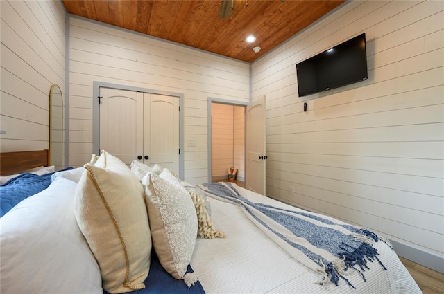 bedroom with recessed lighting, wooden ceiling, and wooden walls