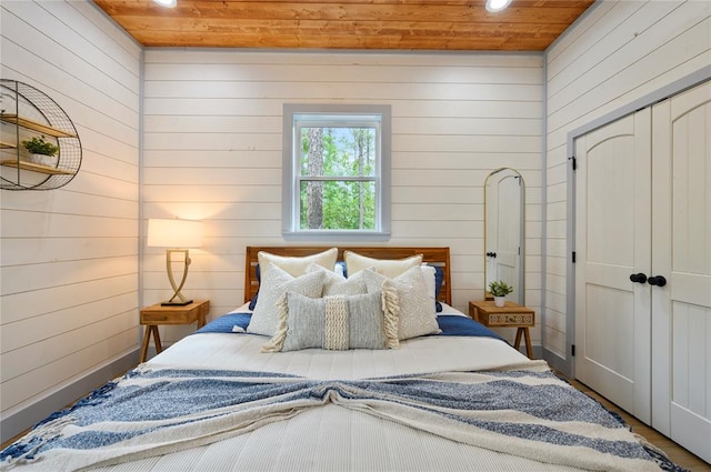 bedroom featuring wooden walls, hardwood / wood-style floors, and wood ceiling