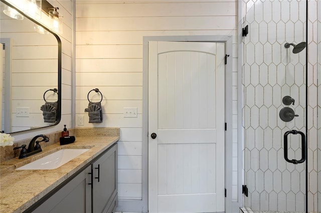 bathroom featuring vanity, walk in shower, and wooden walls