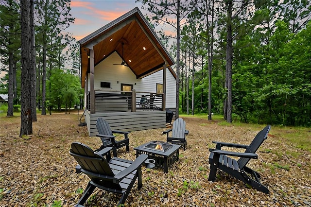 back house at dusk with an outdoor fire pit