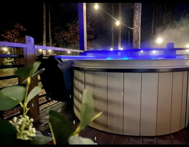 pool at night with a hot tub